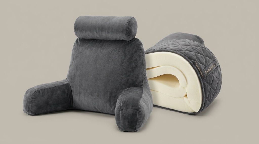 Woman sitting comfortably in bed using a memory foam reading pillow for back support.