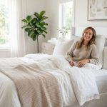 Person sitting up in bed leaning against a contoured support pillow.