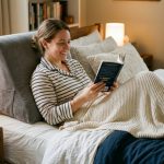 Plush gray reading pillow arranged neatly on a cozy bed.